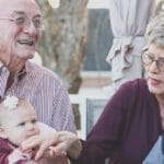 Grandparents spending joyful moments with their grandchildren in an outdoor setting, captured candidly.