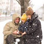 Joyful family playing in the snow on a winter day, capturing warmth and happiness.