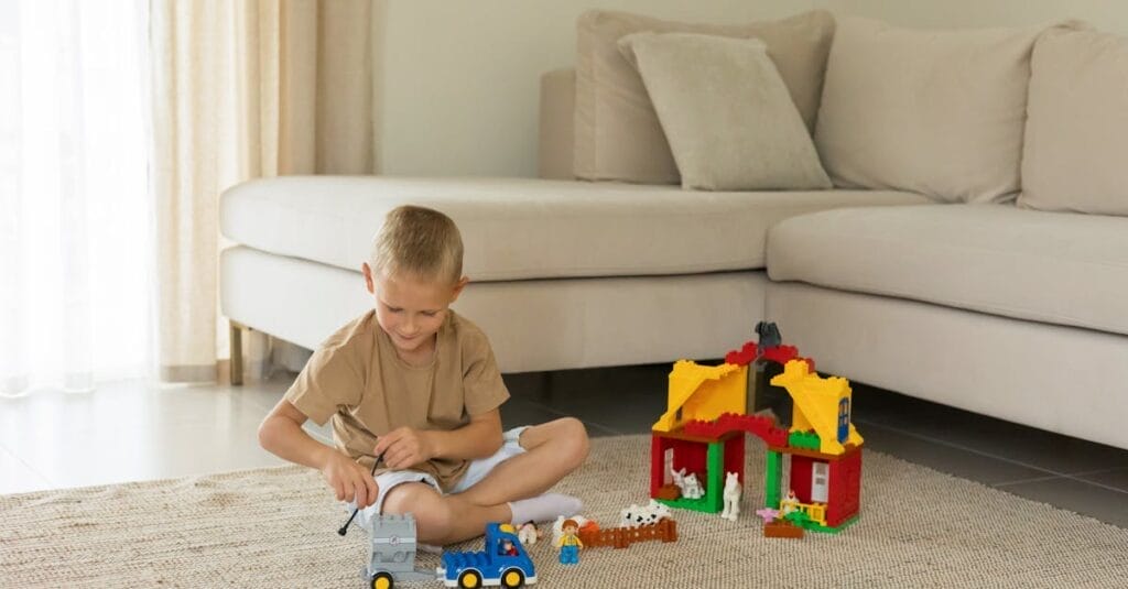 A child enjoys playtime with toy trucks and blocks in a cozy living room setting.