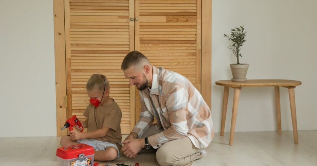 Father and son enjoying quality time assembling a toy kit indoors. Perfect for family and lifestyle themes.