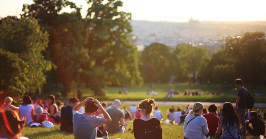 People relaxing and enjoying a sunny day in a bustling city park.