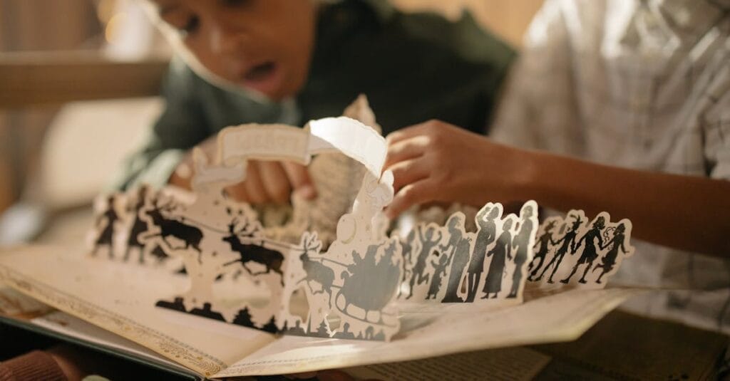 Two children engaged with a pop-up book, capturing the magic of reading indoors.