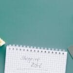 A top-down view of a shopping cart, list, card, and bag on a green background.