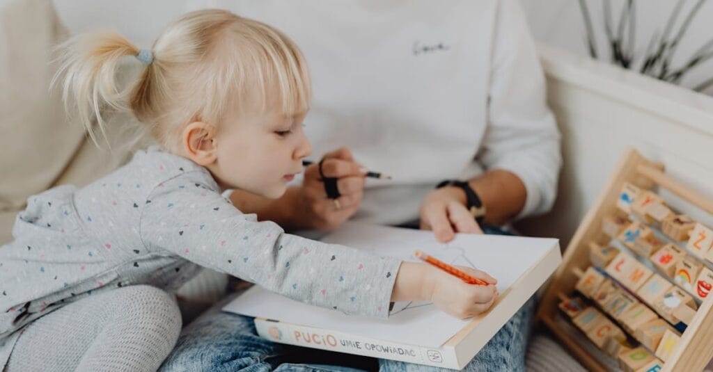 Mother and young daughter bonding over drawing activities at home, fostering creativity.