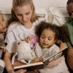 A diverse family enjoys reading a storybook together, fostering warmth and connection.