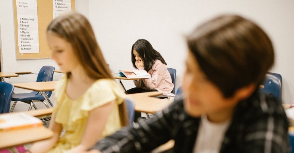 A student sits alone in a school classroom, depicting solitude and contemplation.