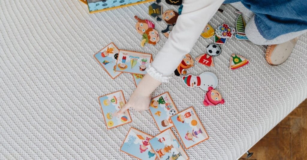 A child engaging with educational flashcards and colorful stickers on a bed.