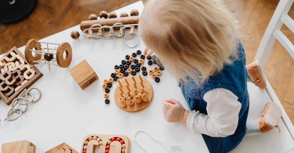 A child engaged in learning with wooden toys at a table, perfect for early education themes.