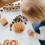 A child engaged in learning with wooden toys at a table, perfect for early education themes.