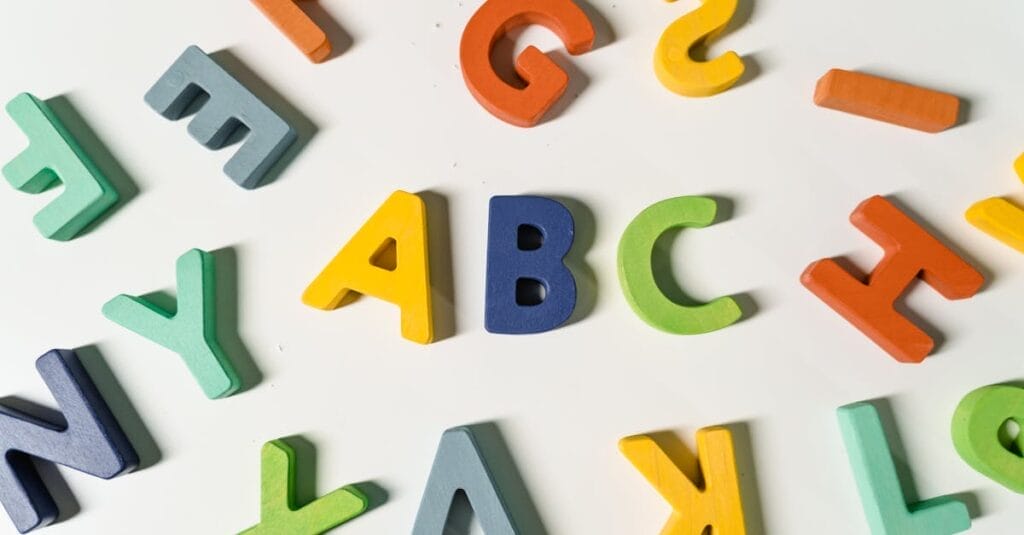 Bright, colorful wooden alphabet letters scattered on a surface ideal for children's learning.