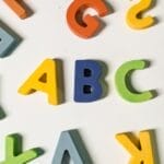 Bright, colorful wooden alphabet letters scattered on a surface ideal for children's learning.