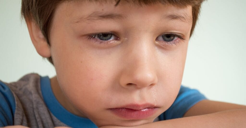 Close-up of a young boy looking sad and emotional, capturing deep feelings.