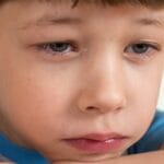 Close-up of a young boy looking sad and emotional, capturing deep feelings.