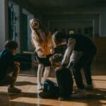 Group of children in a school setting pointing at a seated boy, highlighting school bullying dynamics.