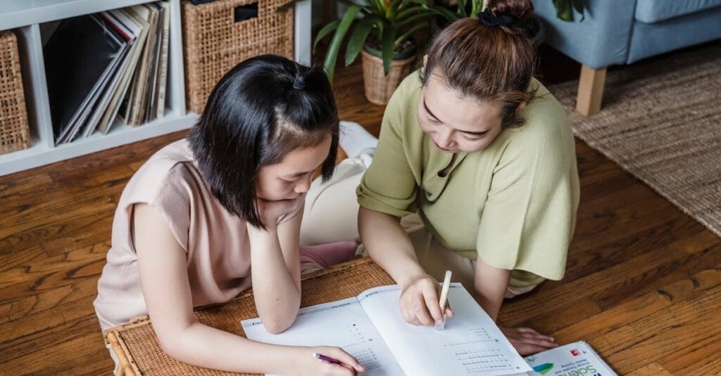 A mother helping her daughter with homework in a cozy home environment, fostering learning.