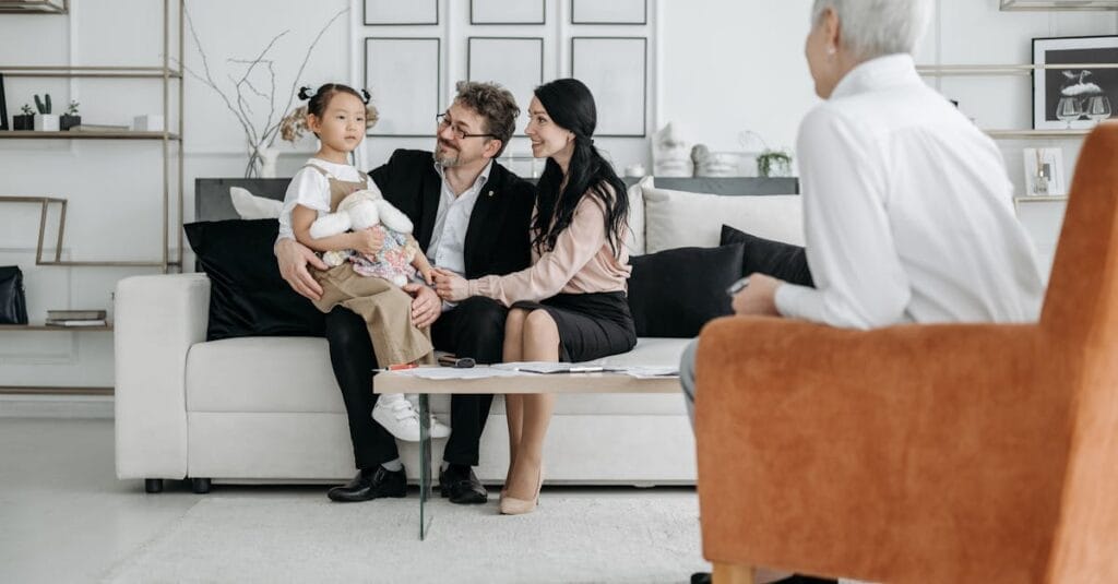 A family meets with a social worker in a cozy living room, discussing adoption details.