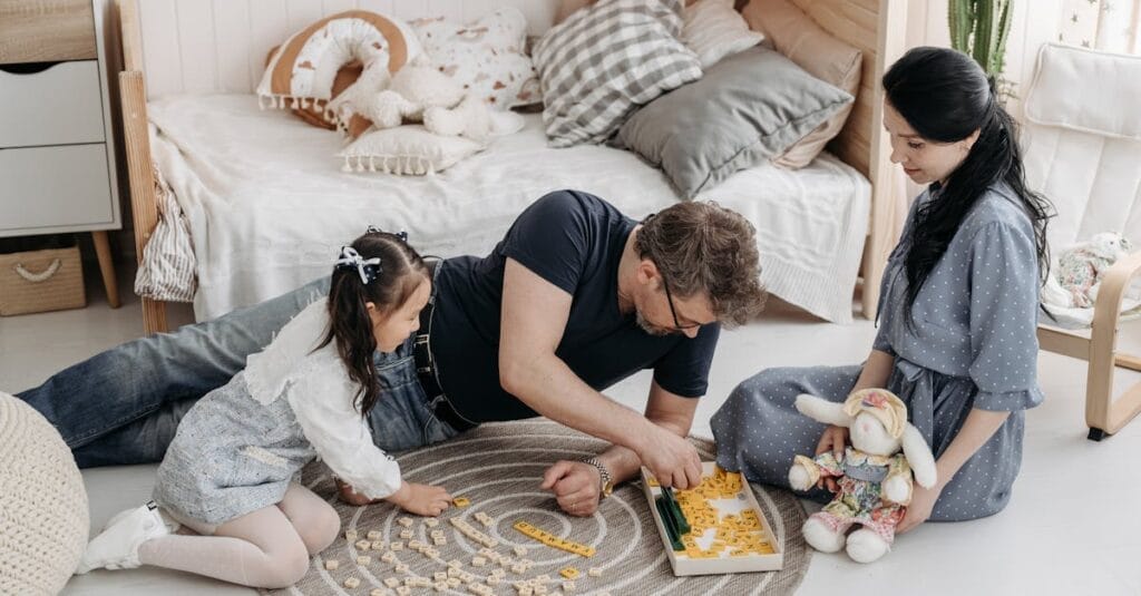 A family enjoying a bonding moment playing Scrabble together in a cozy bedroom setting.