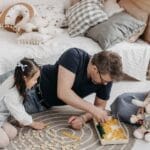 A family enjoying a bonding moment playing Scrabble together in a cozy bedroom setting.