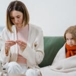 A mother and daughter engage in a telehealth session at home for health concerns.