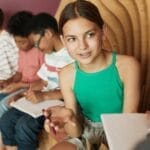 A diverse group of young students engages in a collaborative study session indoors.