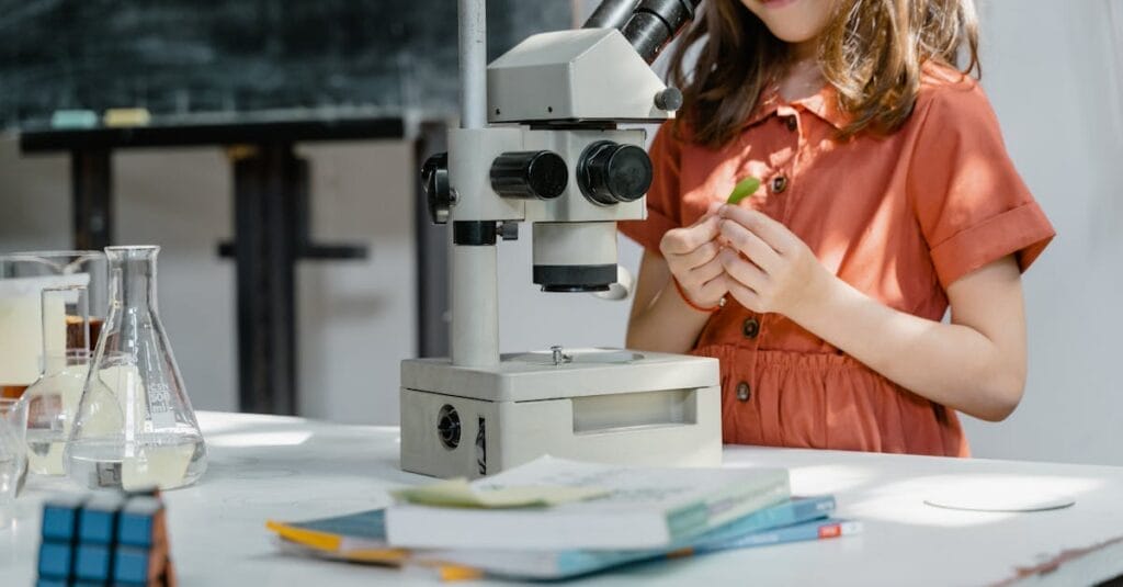 Young girl exploring science with a microscope and lab equipment indoors.
