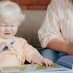 A playful moment between mother and child coloring indoors. Engaging and educational.