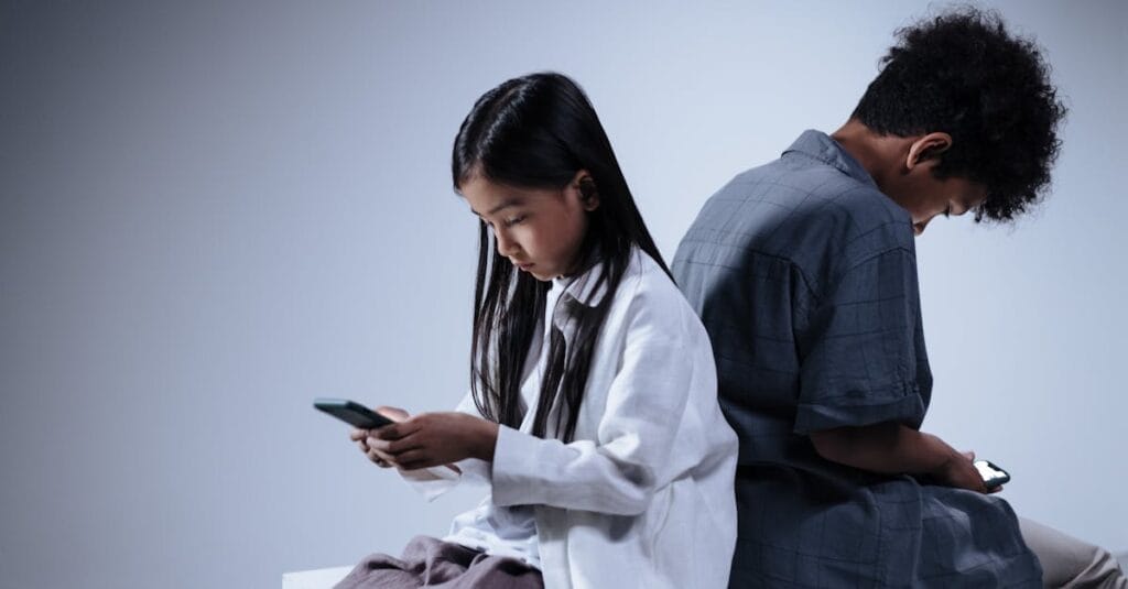 Two teenagers engrossed in their smartphones, highlighting digital connection and youth lifestyle.