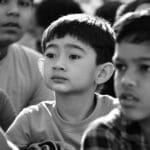 Engaged group of children in a thoughtful moment captured in black and white.