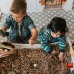 Children engaged in playful activities in a cozy indoor playroom full of toys and imagination.