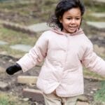 A cheerful child enjoying an Easter egg hunt in a backyard, expressing joy and excitement.
